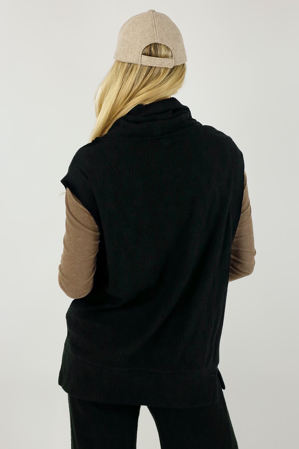 Black Cosy Cowl Vest shown from behind, layered over a camel top, revealing the chevron knit and dropped shoulder.