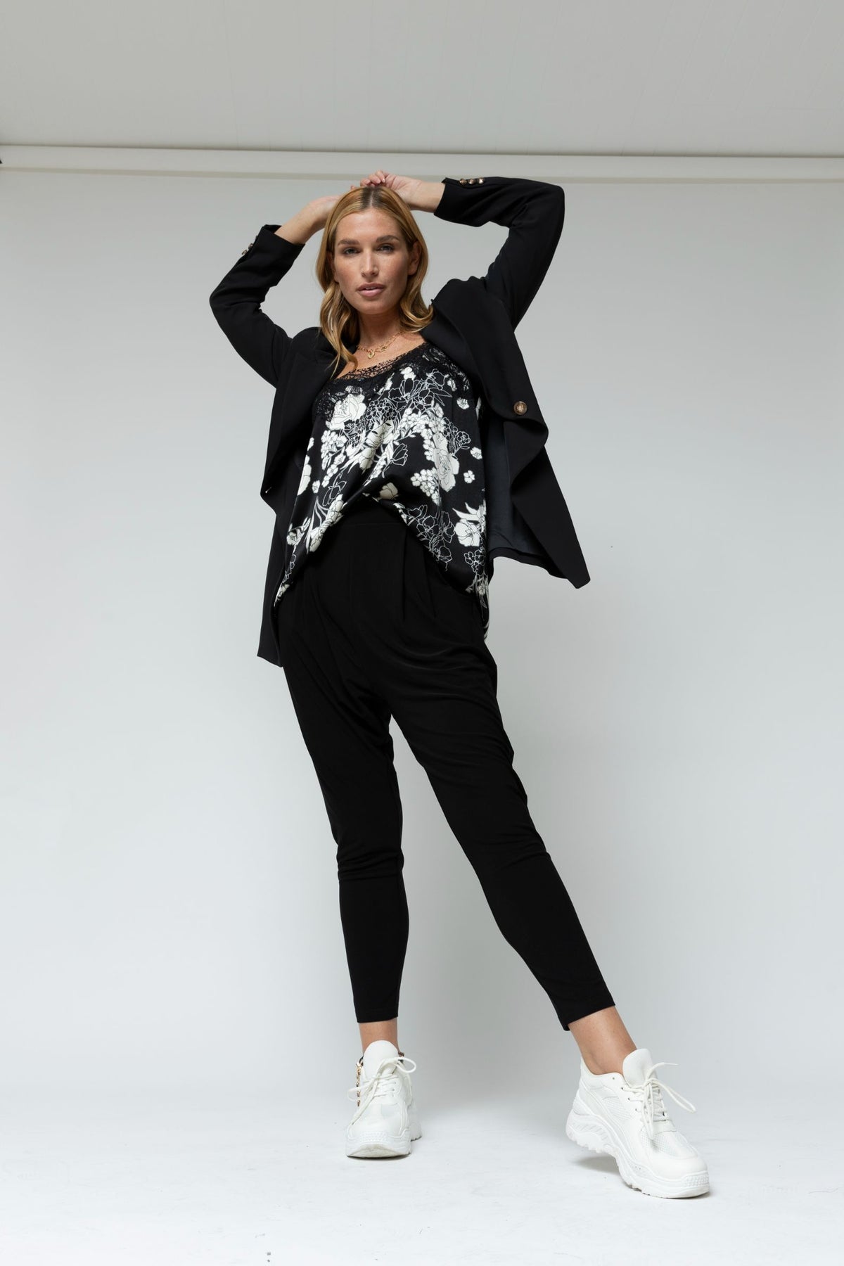 Black Ivory lace cami styled under a tailored blazer with cropped trousers and white sneakers, an effortless elevated look.