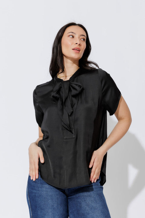 Black silky tie-collar shirt in a relaxed short-sleeve cut, styled with denim for effortless, elevated everyday polish.