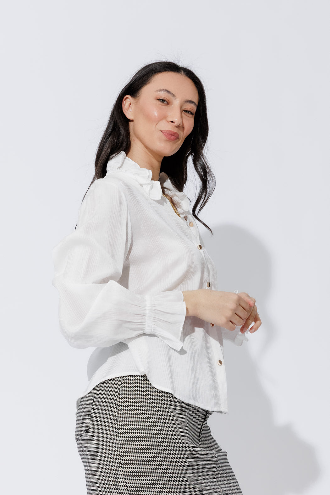 Effortless white frill shirt front view, frill collar, button‑up front and elastic cuffs, sleek contemporary silhouette.