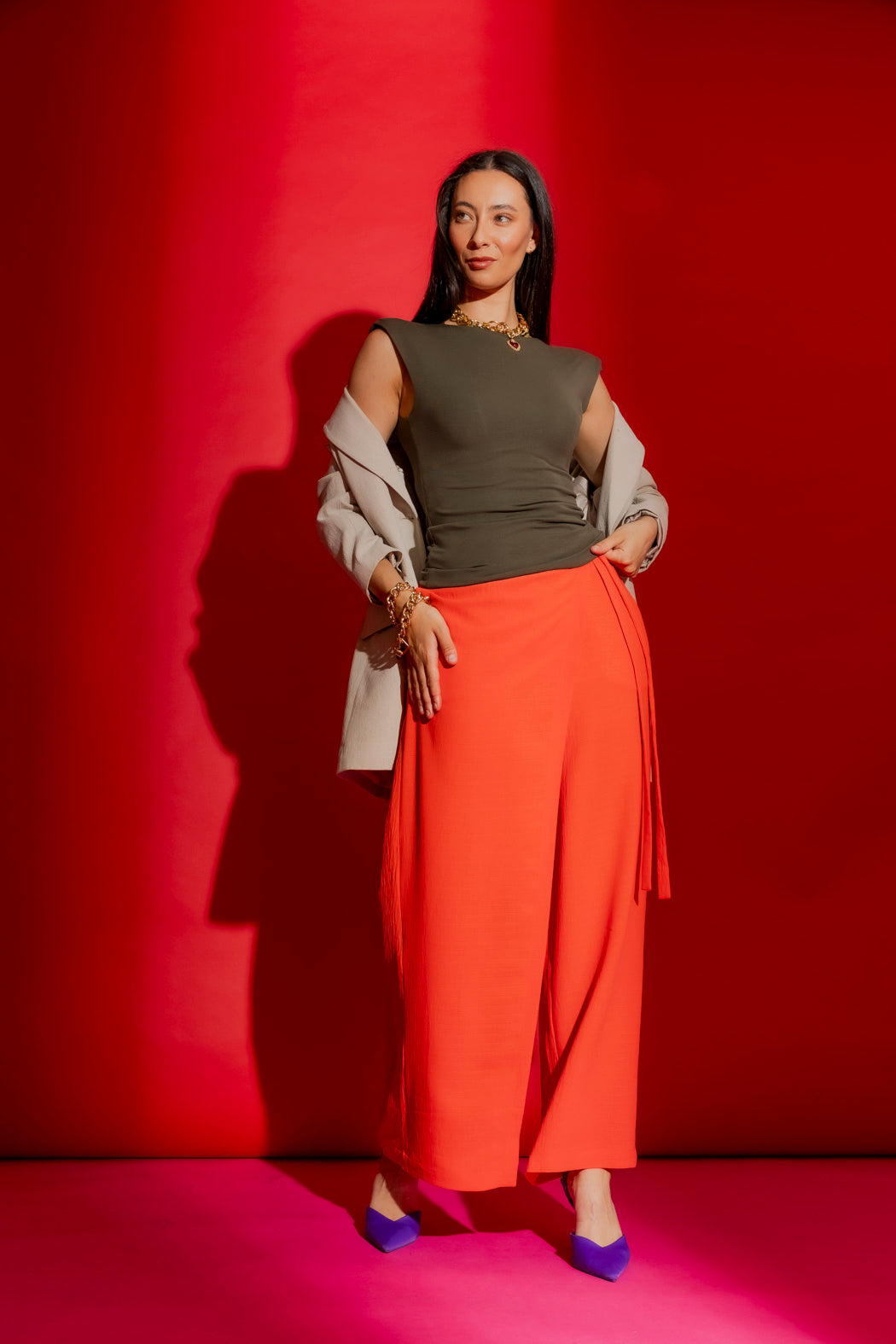 Forest Tencel Lust Cami in deep green, styled with a cream blazer and orange trousers against a bold red backdrop.