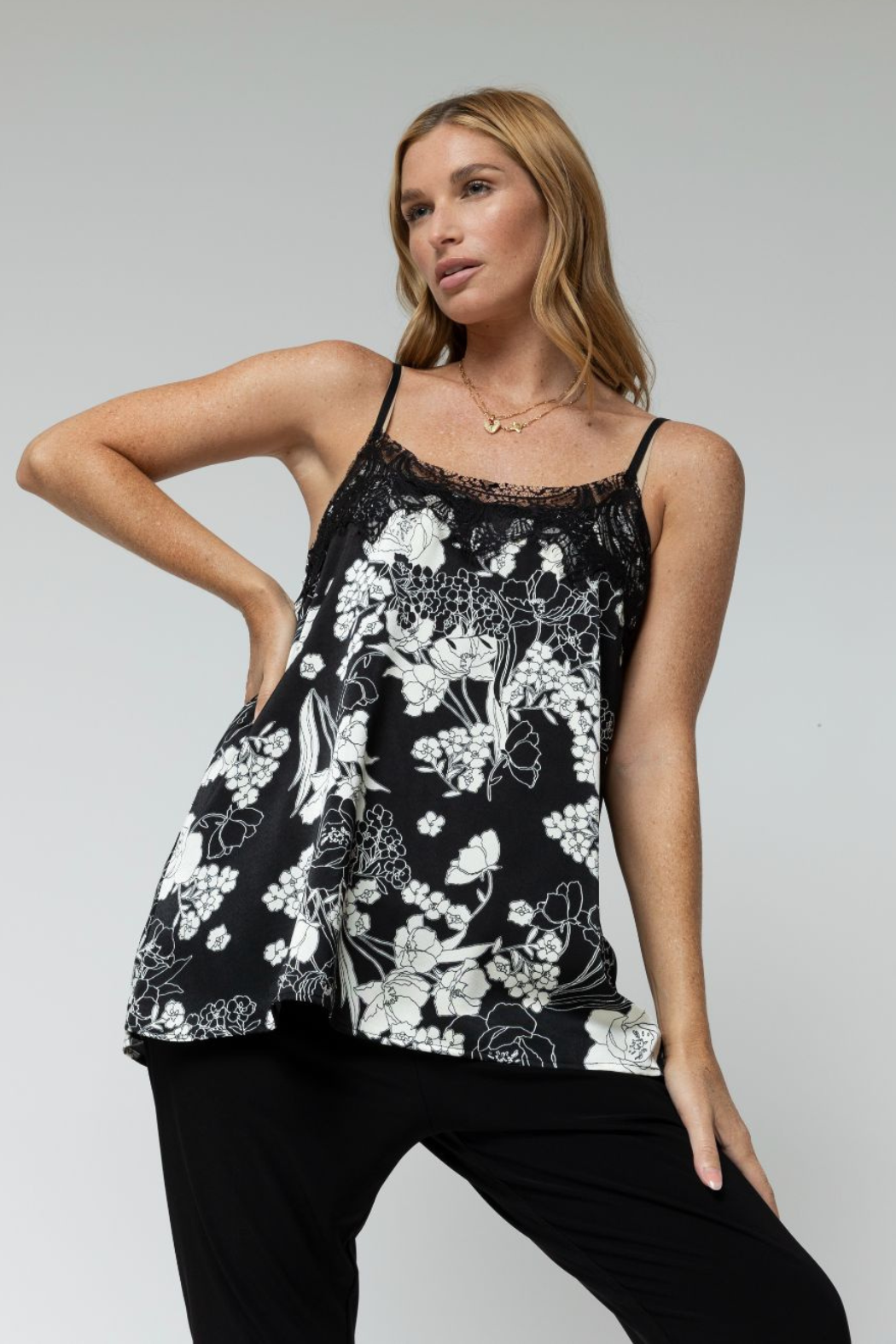 Black Ivory floral lace cami with delicate neckline trim, draped in soft silk and styled with tailored black trousers.