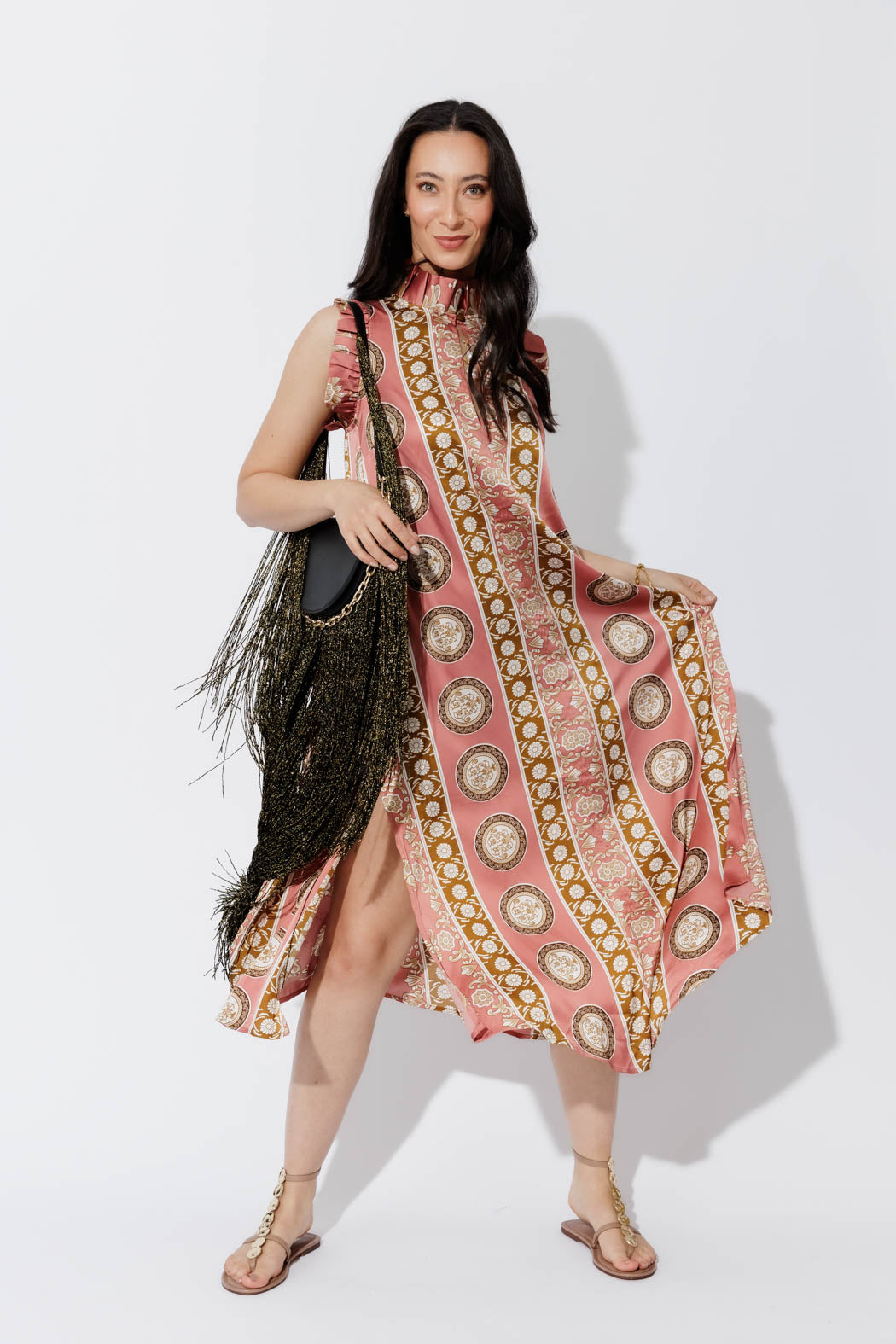 Coral Ruffle Maxi Dress in a medallion print, styled with a fringed bag and flat sandals for effortless summer elegance.