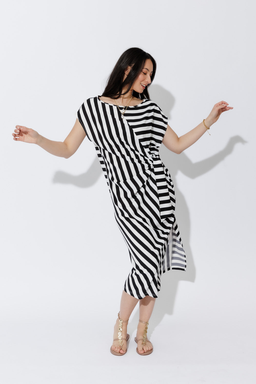 Effortless Bold Stripe Harlow Dress in fluid black-and-white stripes, tie-front detail, gold sandals.