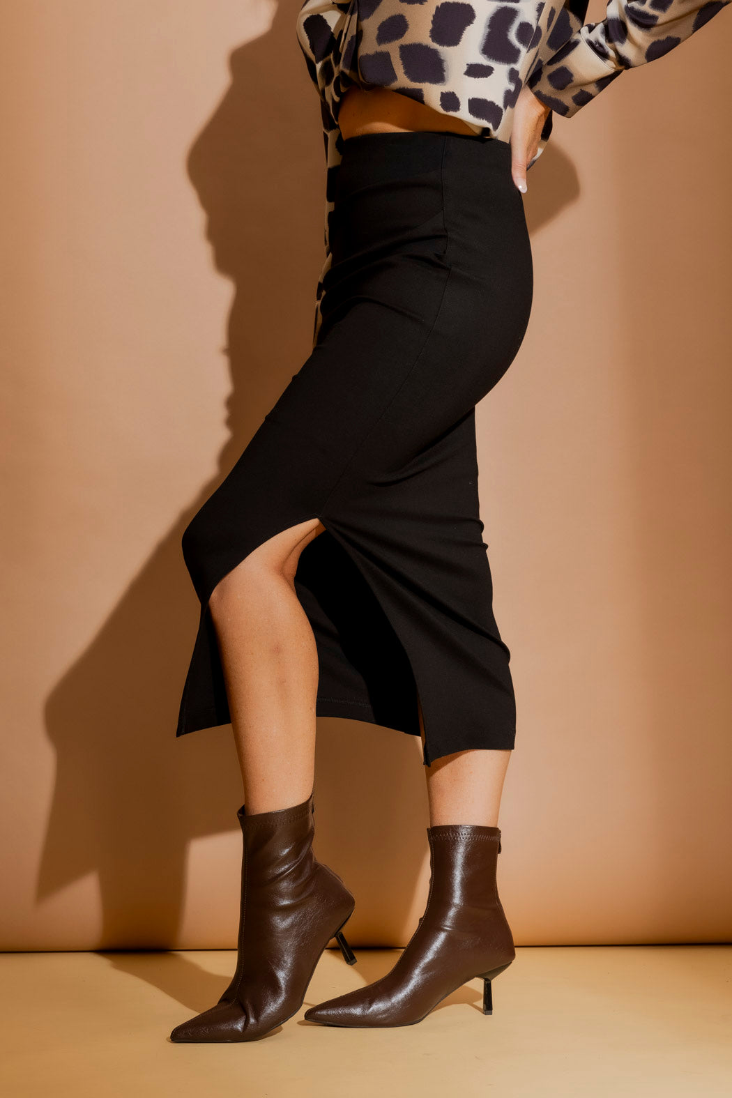 Black Ponte Ruched Miracle Skirt in a sculpted side view, showing side ruching, split hem and elevated sport-luxe styling.