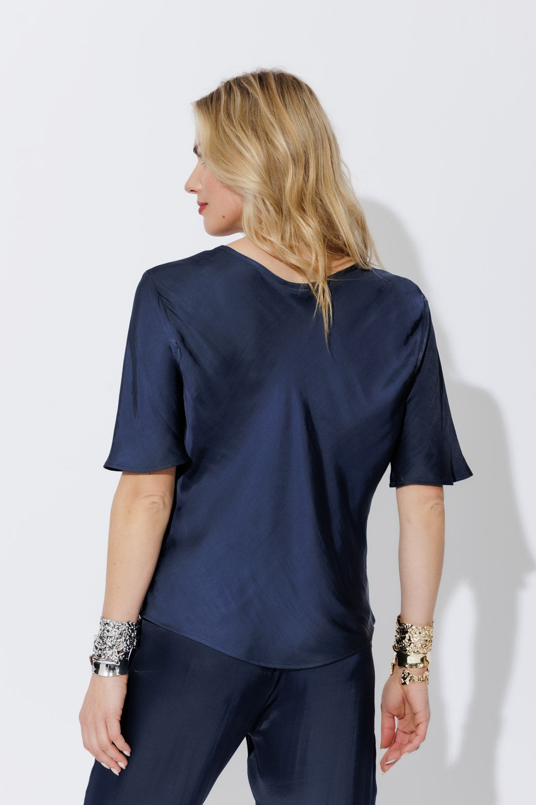 Navy Glow Bias T-Shirt shown from the back, its fluid bias cut draping into a softly structured, contemporary silhouette.