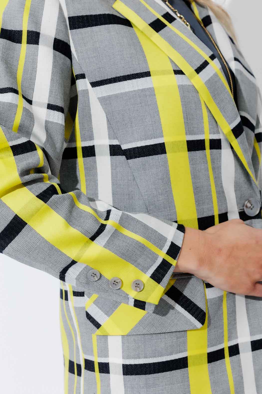Detail of the Neon Check Boyfriend Blazer cuff and lapel, with tortoise shell buttons and a bold woven check in neon yellow.