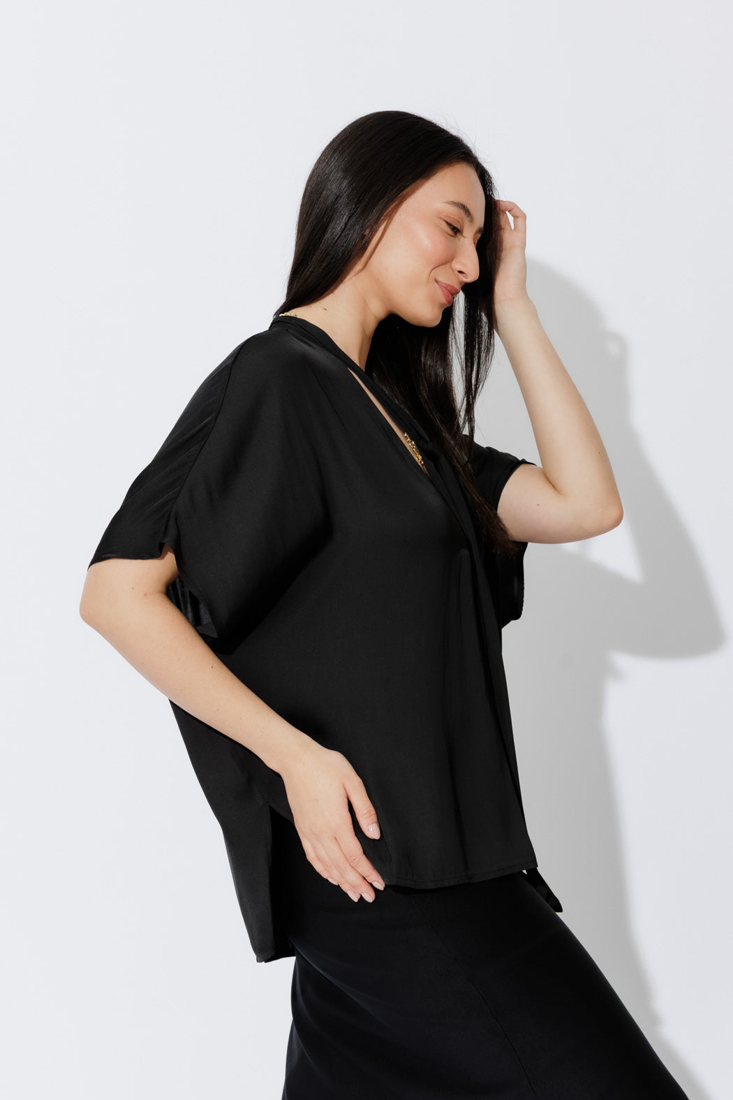 Model wears the Black Tie Bondi Top, oversized silhouette with V‑neck, long side ties and a stepped hem that drapes with ease.