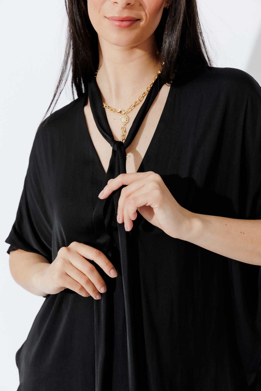 Model showcases the Black Tie Bondi Top in an oversized silhouette, V‑neck and long side ties, stepped hem drapes effortlessly.