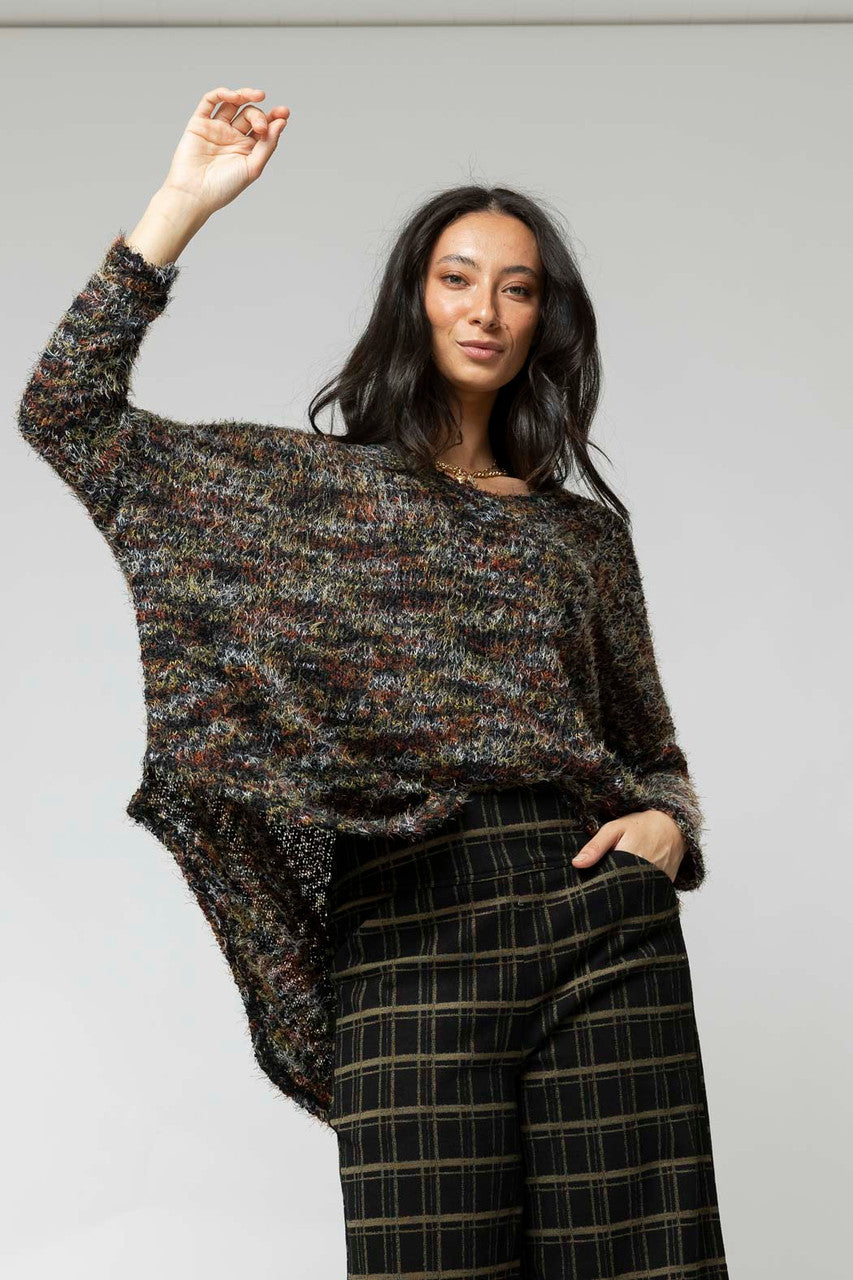 Effortless black speckle fluffy v-neck jumper in a relaxed fit, styled with plaid trousers, revealing the soft knit and hi-lo hem.